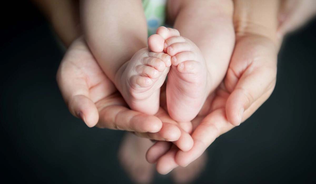 Woman holding baby's feet